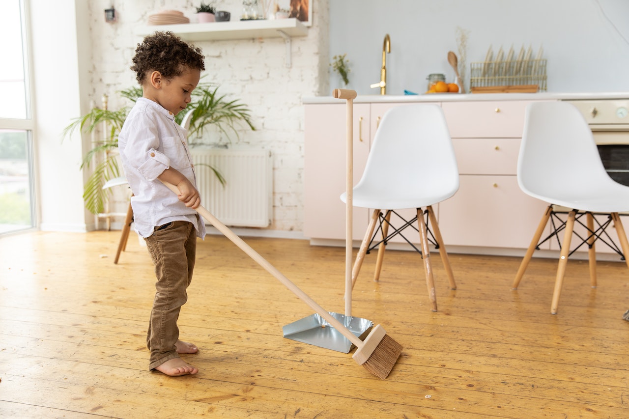 Young boy using the broom